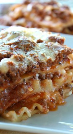 a stack of lasagna casserole sitting on top of a white plate