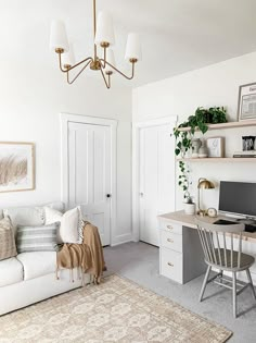 a living room filled with furniture and a computer on top of a desk next to a white couch