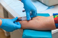 a person in blue gloves is getting an injection from another person's arm and leg