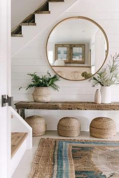 a mirror sitting on top of a wooden shelf next to a stair case filled with potted plants