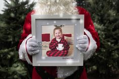 a person dressed as santa claus holding up a photo frame with a coffee cup on it