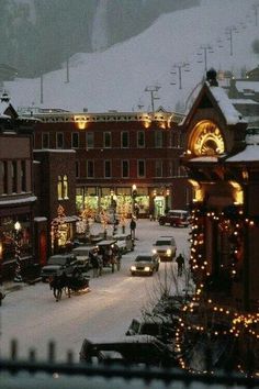 the town is decorated for christmas with lights and cars parked on the side of the road