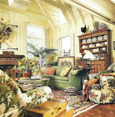 a living room filled with lots of furniture and flowers in vases on the table