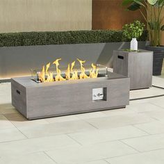 an outdoor fire pit with yellow flames in it