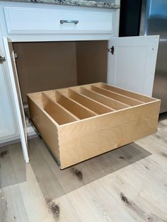 an open drawer in the middle of a kitchen