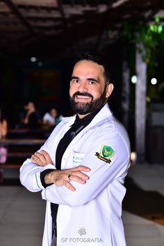 a man in a white lab coat standing with his arms crossed