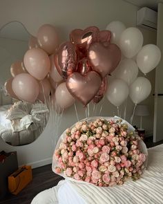 a bouquet of flowers and balloons on a bed