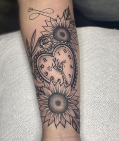 a woman's arm with a clock and sunflower tattoo on it