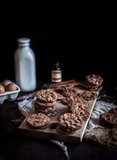 chocolate cookies and eggs on a table with an old fashioned milk bottle in the background