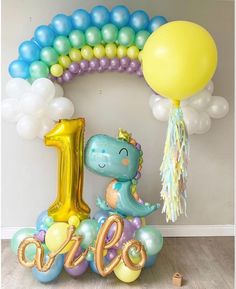 a balloon arch with the number one on it and balloons in the shape of animals