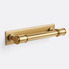 an image of a gold towel bar on a white wall with the handles down and two round knobs at the end