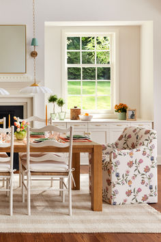 the dining room table is set with four chairs, and there is a fireplace in the background