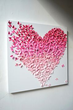 a painting with pink butterflies in the shape of a heart on a white wall above it