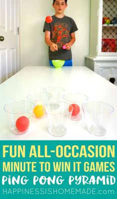 a young boy standing in front of a table with plastic cups and balls on it