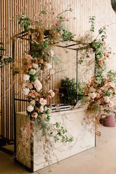 a white marble counter topped with flowers and greenery