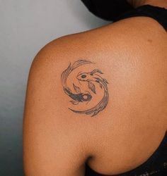 a woman's back with a tattoo on her shoulder and a fish in the middle