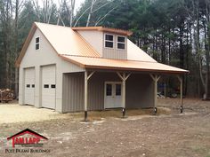 a two car garage with a metal roof in the middle of a wooded area next to trees