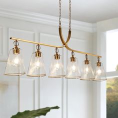 a chandelier with five clear glass shades hanging from it's brass finish