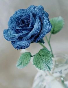 a blue rose sitting in a glass vase