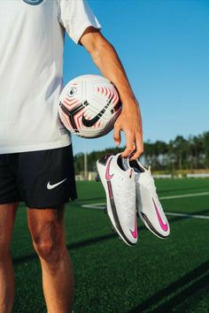 a man holding a soccer ball on top of a field