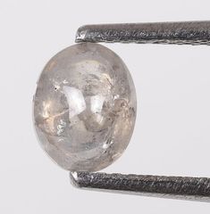 a large crystal ball sitting on top of a piece of metal barbwire next to a white wall