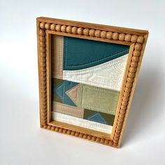 a small wooden frame holding a quilt