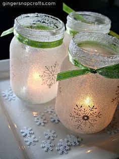 three mason jars with lights in them on a tray