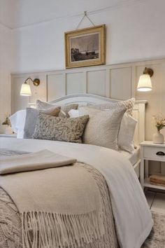 a bed with white linens and pillows in a bedroom