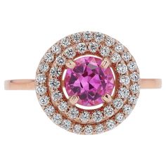 This striking sapphire ring boasts a striking, bubbly, Barbie pink color, perfect for everyday wear. Offered at a spectacular value, this is a fantastic gemstone engagement ring, or right handed statement cocktail ring. With a contemporary rose gold double halo design, we "rescued" an antique 1.07 carat pink sapphire and encircled it with 44 brilliant natural diamonds. Being an antique gem, it shows minor abrasions and a small chip to the edge, visible only under 10x magnification Condition: Setting is new; sapphire is antique (minute abrasions; see description) Era: Contemporary Year: 2024 Metal: 14k Rose Gold Gemstone: Pink Sapphire Carat Weight: 1.07 Cut: Round Color: Pink Clarity: Transparent Accent Diamonds:  44 Round Brilliants 0.25 carats total G-H Color VS Clarity  Graded by GIA st Paraiba Tourmaline Engagement Ring, Barbie Pink Color, Barbie Rosa, Custom Ring Box, Pink Engagement Ring, Pink Sapphire Ring Engagement, Gemstone Engagement Ring, Double Halo Engagement Ring, Diamond Sapphire Engagement Ring