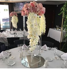 there are many flowers in tall vases on the table at this wedding reception,