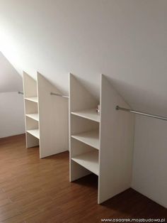 an empty room with white closets and shelves in the corner, on top of a hard wood floor