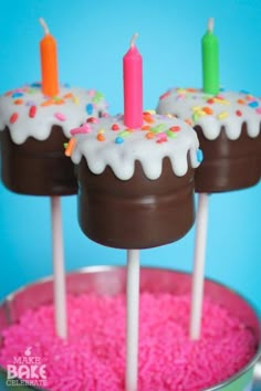 three chocolate covered cake pops with candles on them