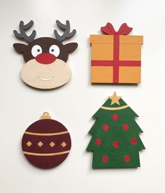 four christmas ornaments are arranged on a white surface, one with a reindeer's head and the other with a present box