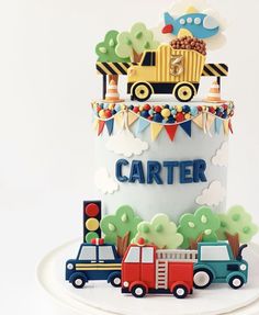 there is a cake with cars on it that says cartier in blue and red