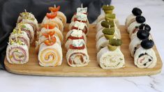 an assortment of sushi rolls on a cutting board