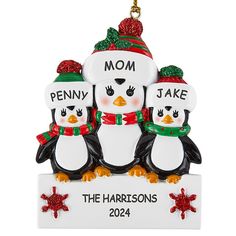 three penguins with hats and scarfs are hanging from a christmas tree ornament