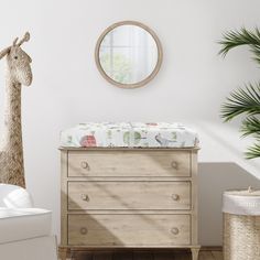 a baby's crib with a giraffe toy hanging on the wall