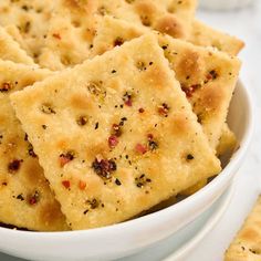 some crackers are in a white bowl on a table