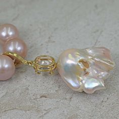 For Sale on 1stDibs - Gorgeous, large peachy pink Baroque Pearl, oval 5.04 carat Morganite and accent white diamond 14k yellow gold enhancer pendant on a graduated, round 12-15mm