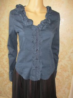 Black long sleeved shirt with a ruffled neck line and  button band.  The back is stretchy and the front cotton.  It has buttons to close and buttons on the cuffs. Bust pit to pit flat;  19" Length;  22" Inside arm;  19" Made by PORTO FORTUNA Elegant Stretch Tops With Ruffled Collar, Long Sleeve Cotton Blouse For Fall, Elegant Stretch Top With Ruffled Collar, Stretch Cotton Fall Shirt, Casual Shirt With Ruffled Collar For Fall, Fall Cotton Collared Blouse, Fall Cotton Blouse With Collar, Fall Cotton Blouse, Fall Button-up Ruffled Shirt