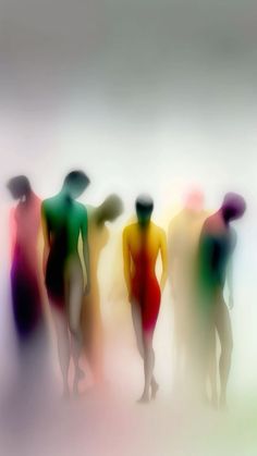 a group of people standing next to each other on a white surface with colored shadows