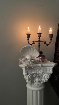 a white pedestal with candles and jewelry on it