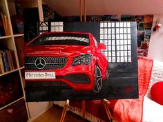 a painting of a red car is on display in front of a bed and bookshelf