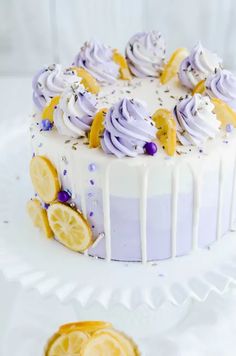 a white cake with purple icing and lemon slices