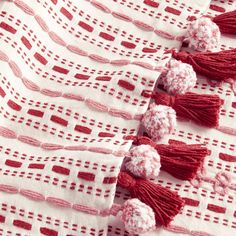 red and white crocheted fabric with tassels on it's edges