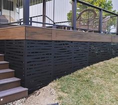 a wooden deck with metal railing and stairs