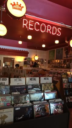 the inside of a record shop with various records on display and neon signs above it