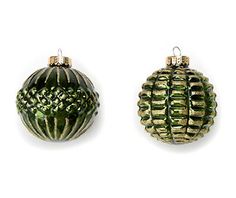 two green christmas ornaments on a white background