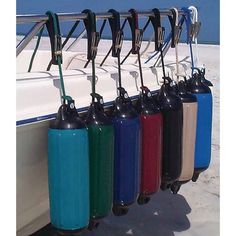 a row of water bottles hanging from a rack on the side of a white boat