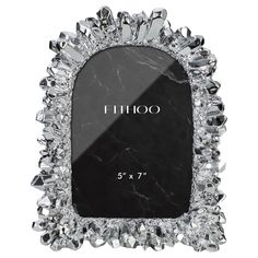 a black and white photo frame with crystals on the edges, in front of a white background